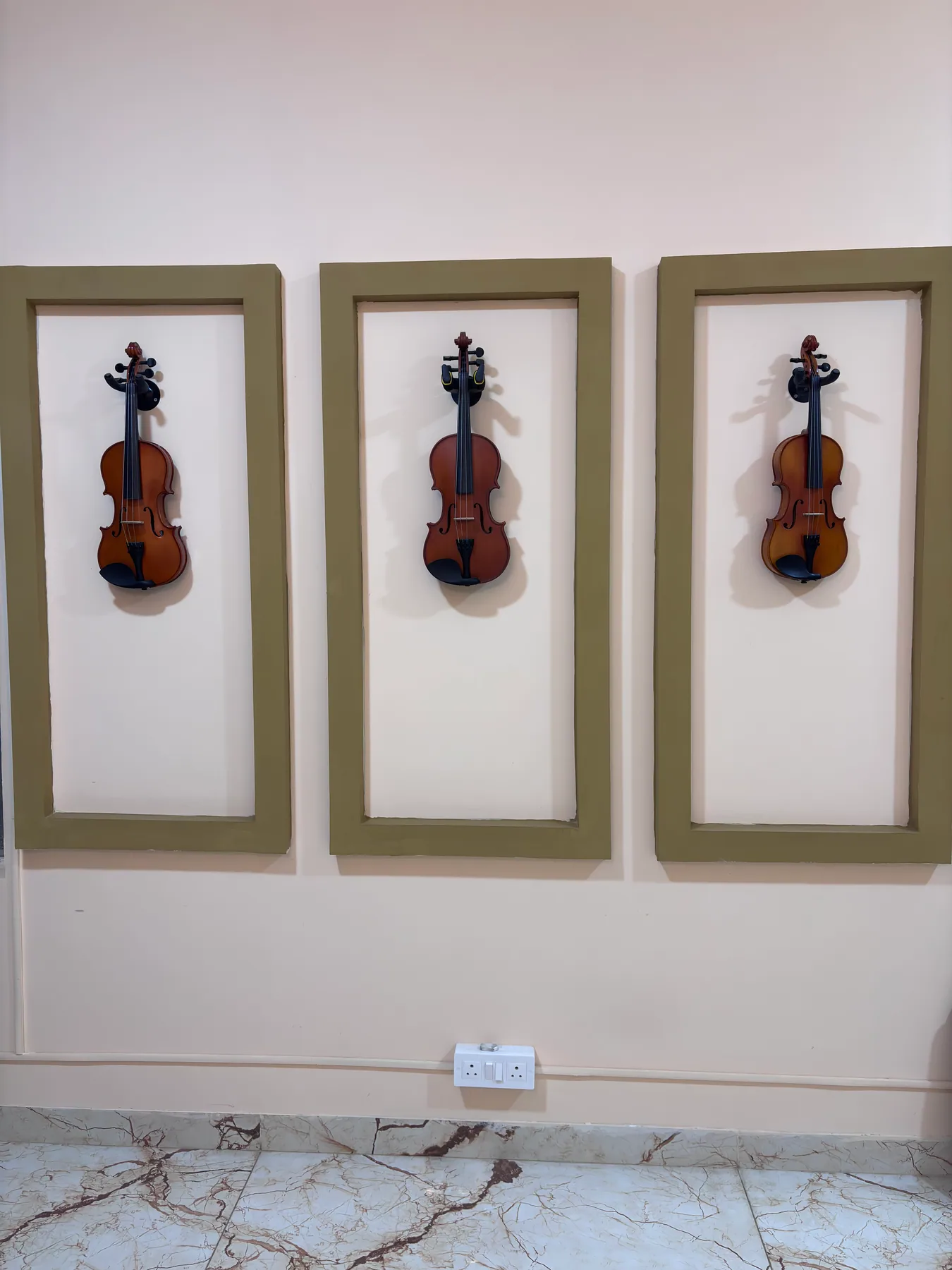 Three violins displayed inside Advaya Music Academy